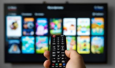 Male hand holding TV remote control