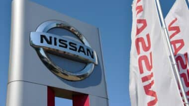 Official dealership sign of Nissan against blue sky