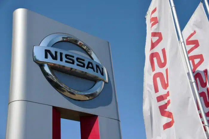 Official dealership sign of Nissan against blue sky