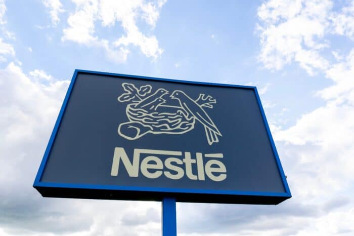 Close up of Nestle ground sign with blue sky in background.