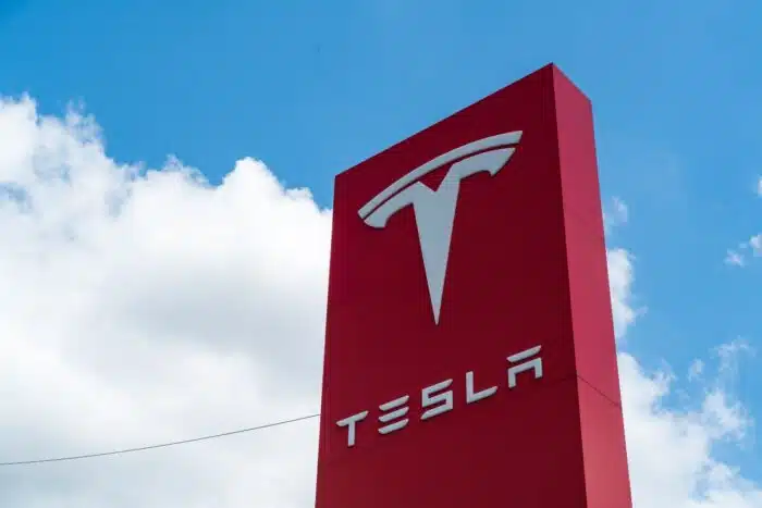 Tesla Motors Red sign in the growing pond springs location overflowing with Electric Tesla Vehicles