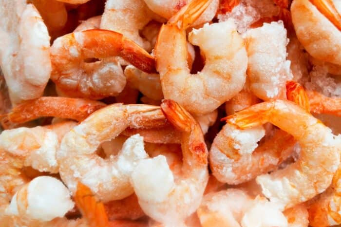 Raw frozen and peeled shrimp background. Pile of frozen shrimps.