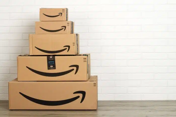 group of Amazon cardboard boxes on white brick wall background.