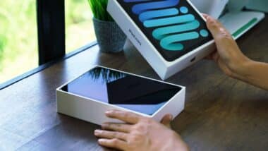 Close up hand opening box of new Ipad mini gen 6 order from Apple store online