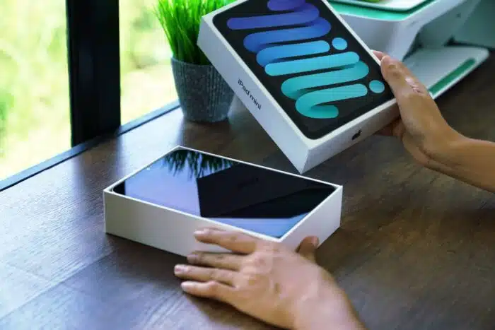 Close up hand opening box of new Ipad mini gen 6 order from Apple store online