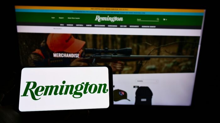 erson holding cellphone with logo of US company RemArms