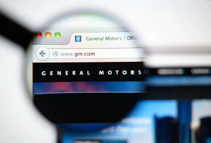 Photo of General Motors homepage on a monitor screen through a magnifying glass.