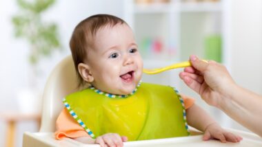 baby eating food on kitchen