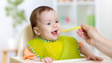 baby eating food on kitchen