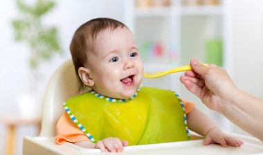 baby eating food on kitchen