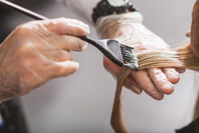 Hairdresser is dying female hair