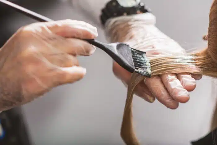 Hairdresser is dying female hair