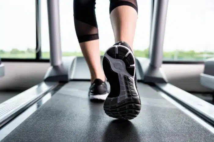 Close up of woman's legs feet as she walks on treadmill - treadmill horsepower - bowflex treadmills - nautilus treadmills - treadmill lawsuit