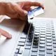 A person uses a credit card to make a purchase on their laptop - stubhub fees