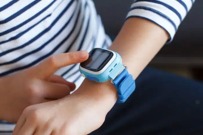 School girl looking at her smart watch phone. Time clock.