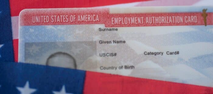 Employment Authorization card on USA Flag surface.