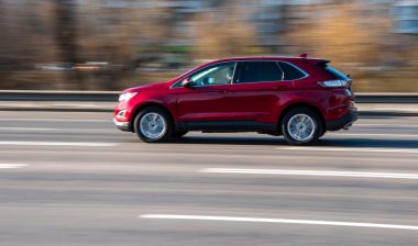 Red Ford Edge car moving on the street;