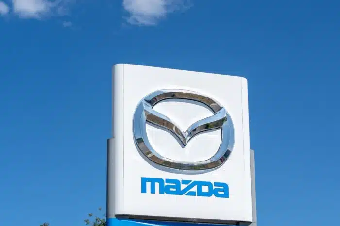 Close up of Mazda sign with blue sky in background.