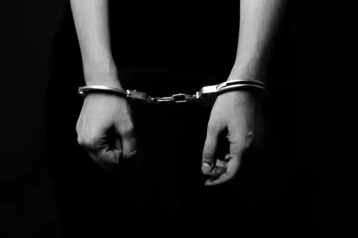 Black-and-white image of handcuffed hands, representing the New Jersey Department of Corrections IDEA violations prison education class action settlement.