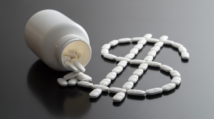 Dollar sign written with pills spilled from a medicine bottle - Vyera Pharmaceuticals - daraprim price - malaria drugs settlement