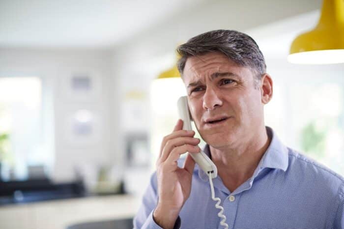 Frustrated Mature Man Receiving Sales Call At Home - West Shore Home