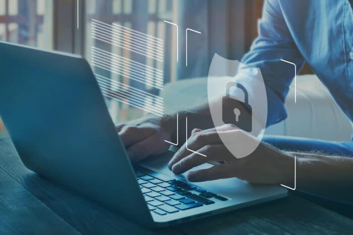 Photo of person typing on computer, security breach concept.