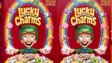 Boxes of General Mills Lucky Charms cereal on super market shelf.