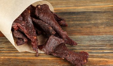 Beef jerky on a wooden board close-up.