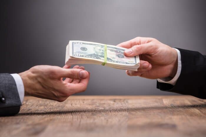 Close-up Of A Person Giving money to another person.