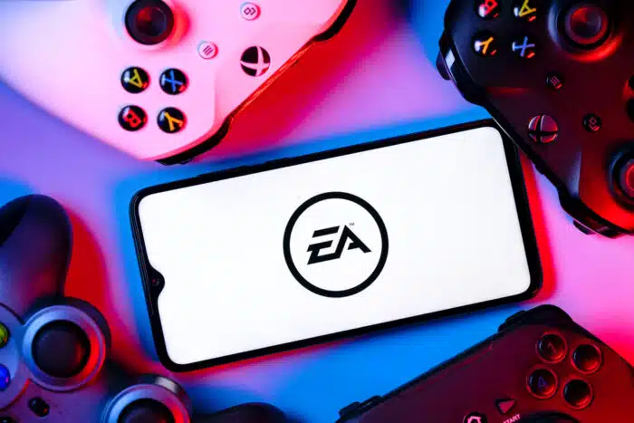 A smartphone with the Electronic Arts logo on the screen surrounded by gamepads.