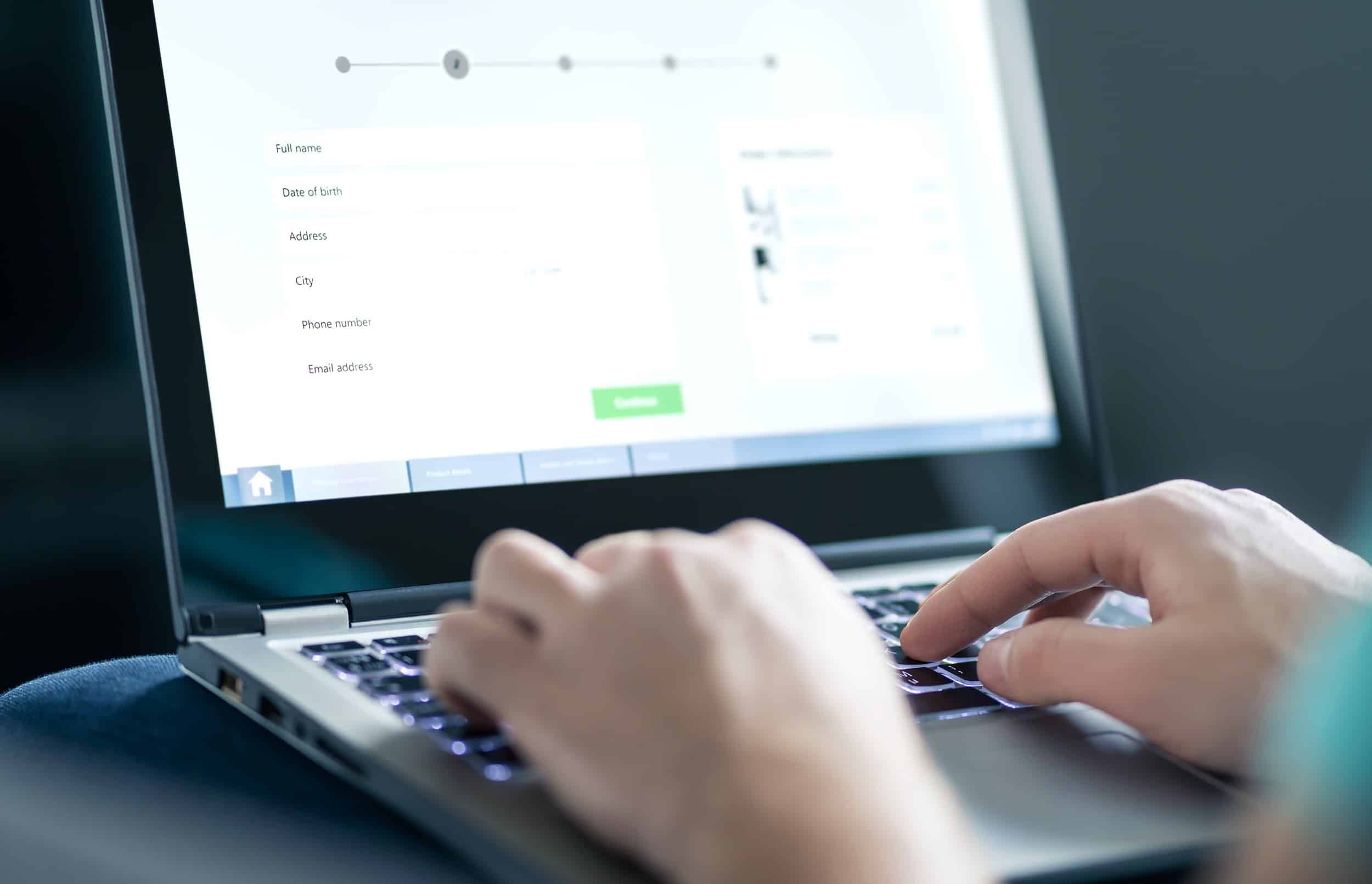 A person fills out an online form using a laptop - 2022 settlements