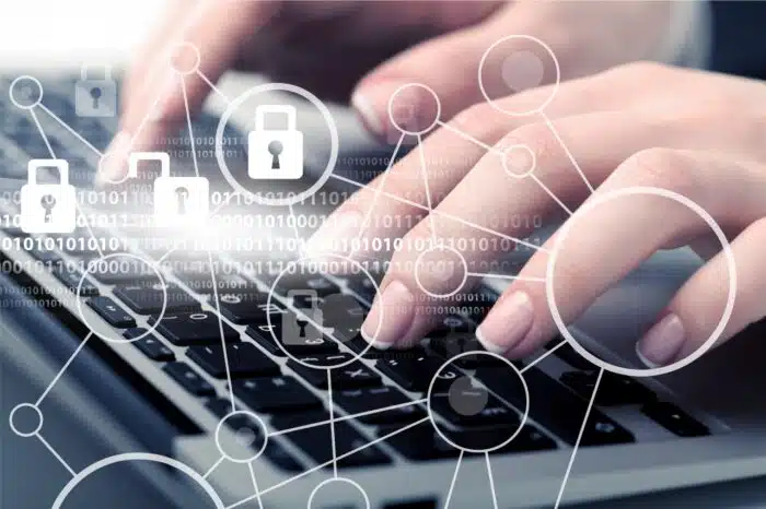 Closeup of a person typing on a laptop, with padlock and network graphics overlaid - solara medical settlement - Solara Medical Supplies data breach