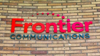 Frontier Communications trademark logo and sign on the office of telecommunications company.