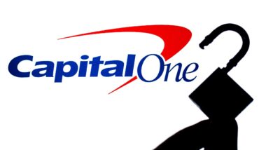 Capital One Bank logo on the screen in a main focus and a blurred silhouette of the opened lock.