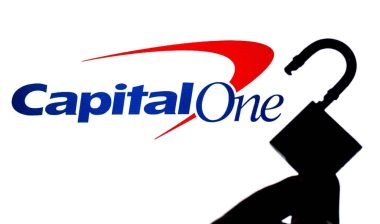 Capital One Bank logo on the screen in a main focus and a blurred silhouette of the opened lock.