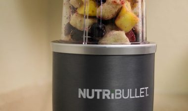 Nutribullet with a container of frozen fruit ready to be blended