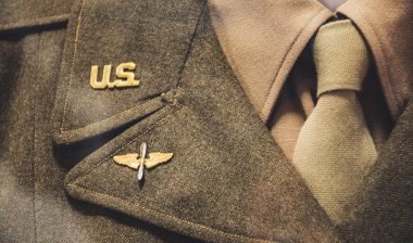 Gold-colored U.S. Brooch on military uniform.