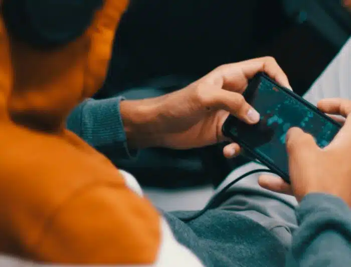 Teenager playing a game on his smartphone - clash royale brawl stars class action