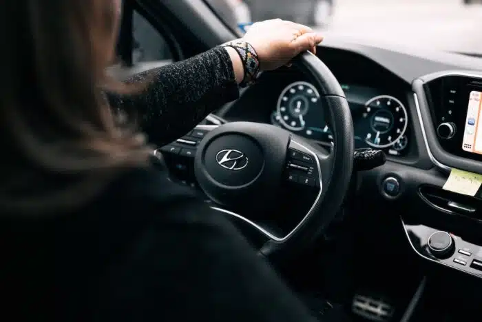 Woman sitting in driver seat of a Hyundai vehicle.
