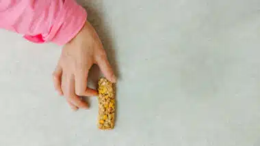 Person holding a granola bar.