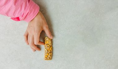 Person holding a granola bar.
