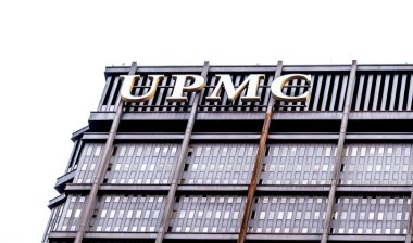 UPMC sign on the building in Pittsburgh. The University of Pittsburgh Medical Center (UPMC) is a integrated global nonprofit health enterprise.