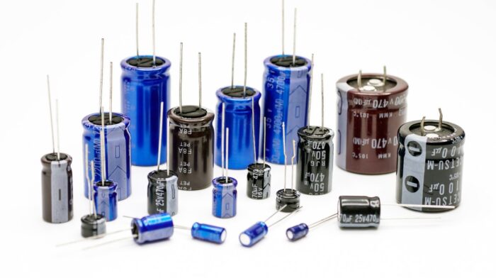 Electrolytic capacitors, many colors and sizes, white background, electronic component concepts