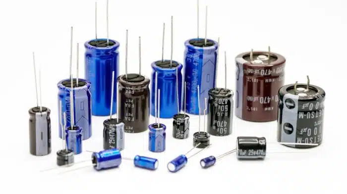 Electrolytic capacitors, many colors and sizes, white background, electronic component concepts