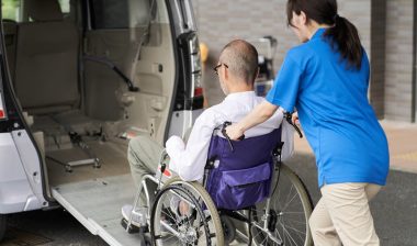 A caregiver who puts an elderly person in a medical transport van