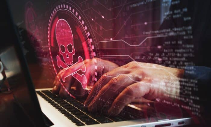 Skull pirate, online cyberattack, hack, threat and breach security symbol and man typing computer keyboard - abs data security incident settlement, american bank systems data breach