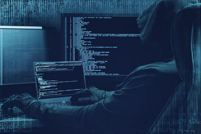 Hacker working on a code on dark digital background with digital interface around - data security - data privacy