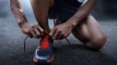 Man tying running shoes.