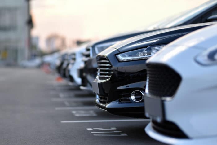 Close up of various auto vehicles in a parking lot - toyota tundra, ford recall