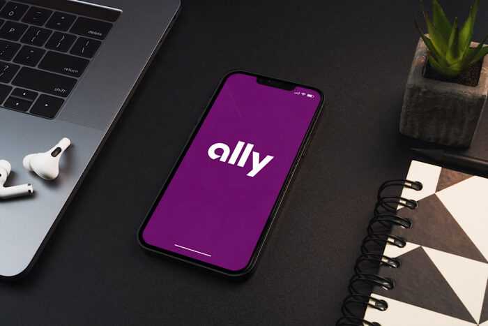Ally financial bank app on the smartphone screen on black background table.